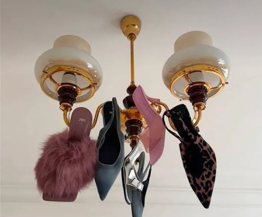 Designer heels hanging from a vintage chandelier